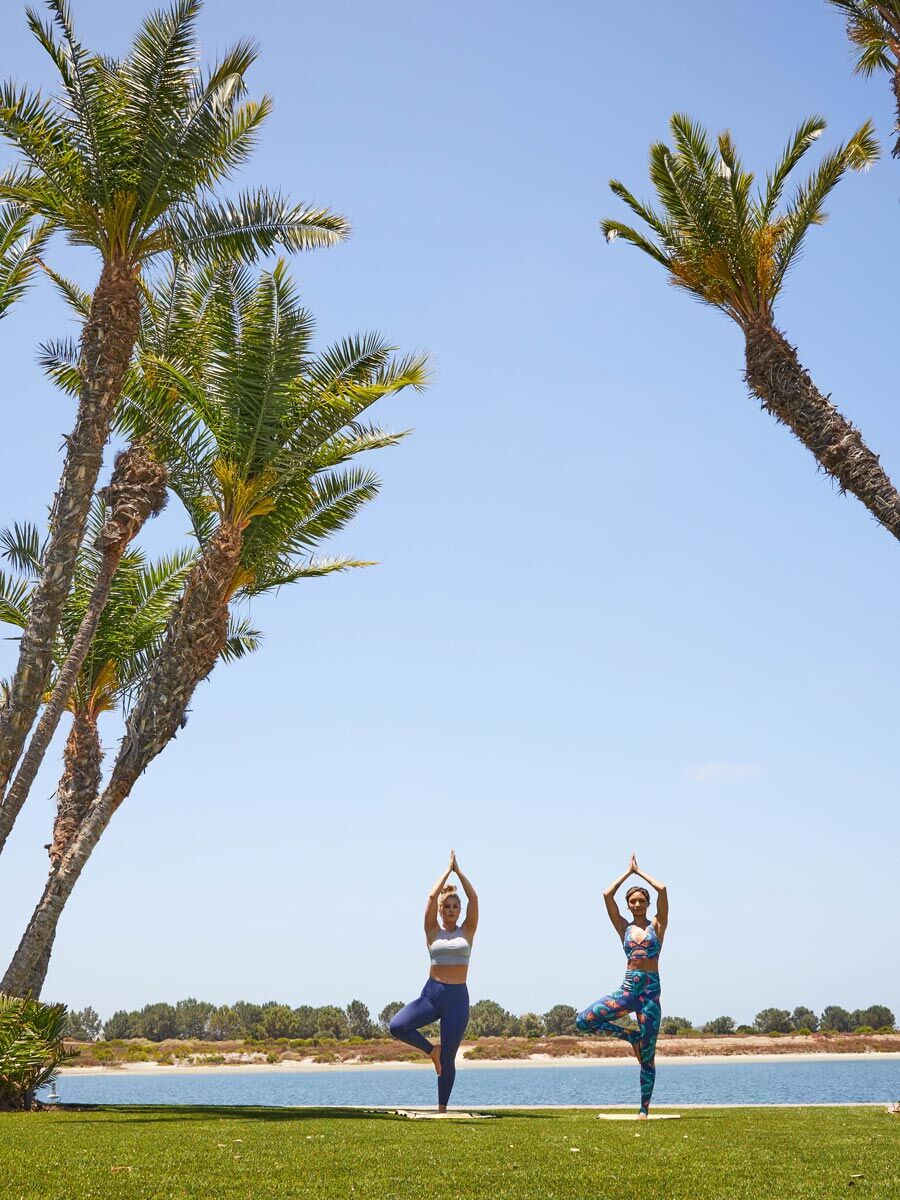 People doing yoga on the beach.